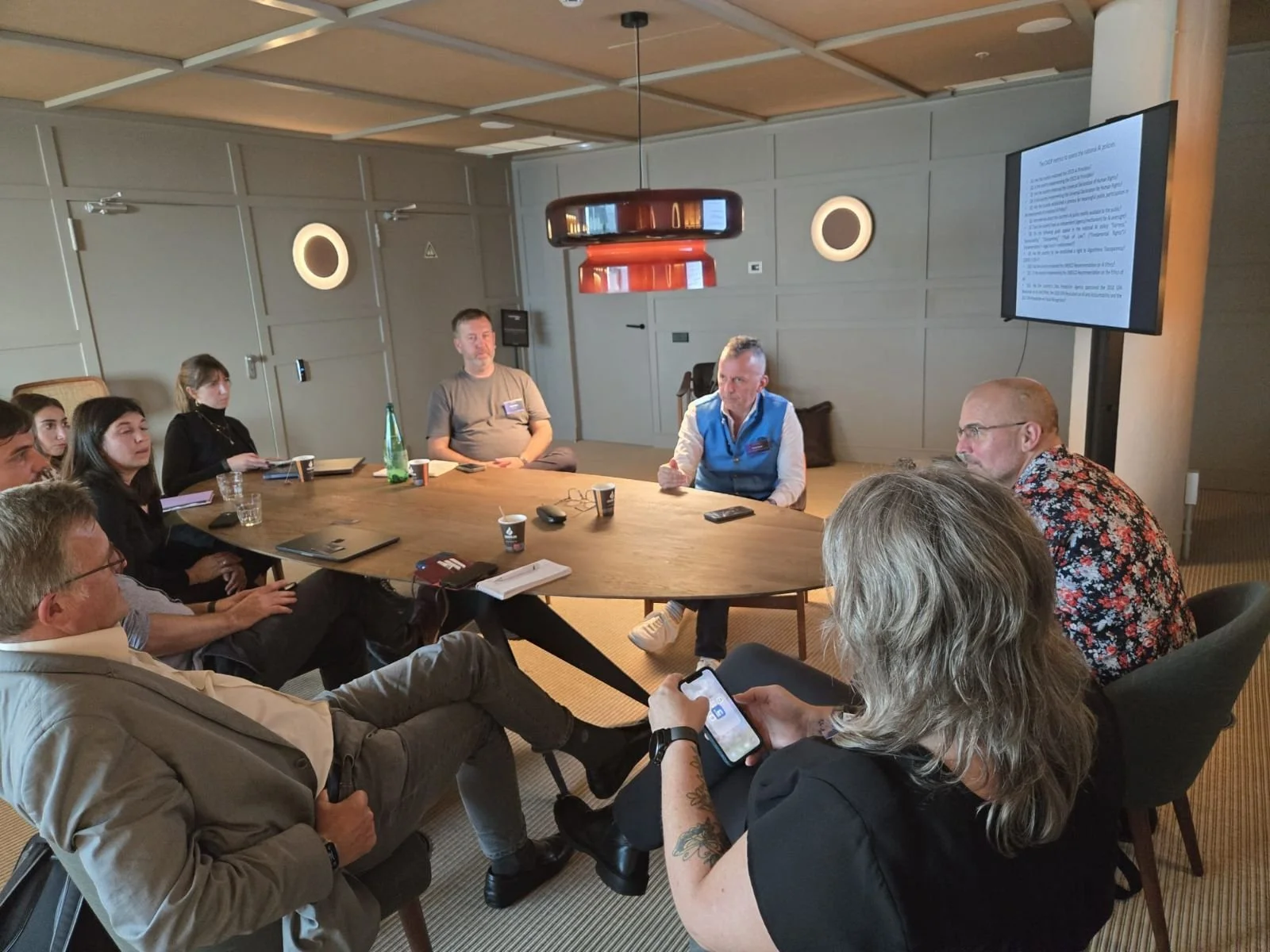 People exchanging ideas around a circular table during an ECOSYSTEM working session